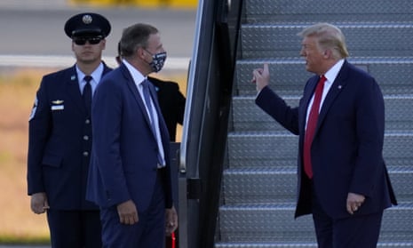 New Hampshire Gov. Chris Sununu (masked), greets president Trump as he arrived for a campaign rally last month.