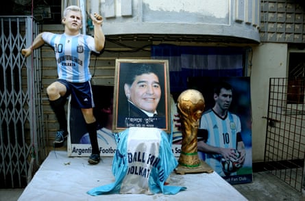 A statue and poster of Lionel Messi, and a photograph of Maradona, in front of the Argentina Football Fan Club in Kolkata