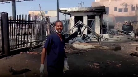 A doctor points to damage outside the East Nile hospital in Khartoum, where airstrikes and street battles have forced thousands to flee in recent weeks.