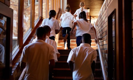 Young students running up stairs at the school
