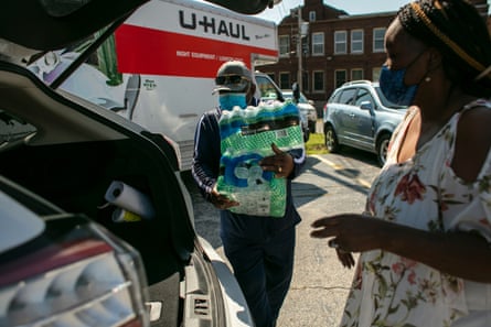 Volunteers load cases of water into resident’s cars at the clean water giveaway event on 10 September in Benton Harbor.