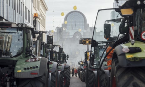 Tractors lined up in a city street, blocking it
