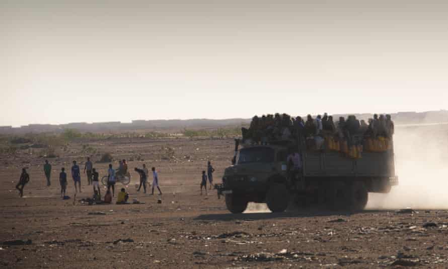 Migrants cross the Sahara desert on a truck.