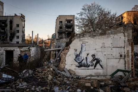 Graffiti of a child throwing a man on the floor in judo clothing is seen on a wall amid damaged buildings in Borodyanka.