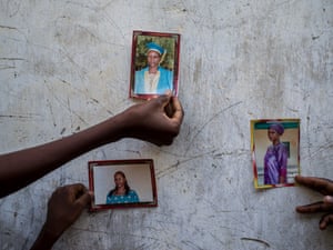 Family members hold up photos of Paulina, 42, who was abducted four months ago during a Boko Haram attack. Since then her family have had no news of her.