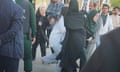 A video still of Iran's morality police arresting a woman with no hijab.