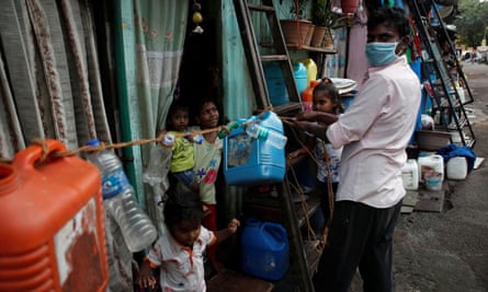 A man ties a rope outside his home in Dharavi to prevent his children from going outside, and other people from coming inside.