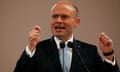 Joseph Muscat raises both hands while talking into a microphone