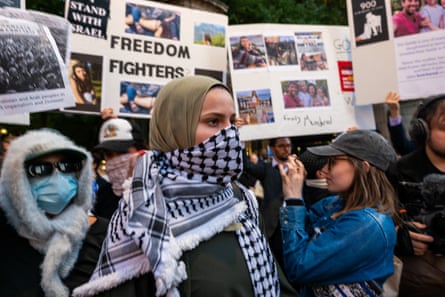 people crowded together under protest signs addressing Gaza