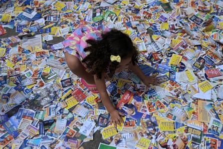 A girl plays with political flyers at the Cidade de Deus favela, in south-west Rio de Janeiro, on polling day.