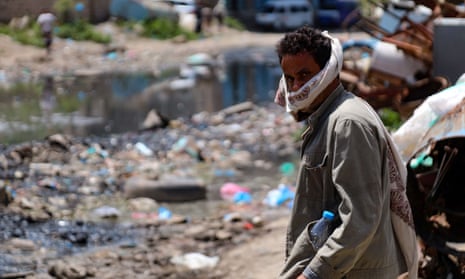 A man wears a face covering beside a rubbish-strewn street in Yemen’s third city of Taez
