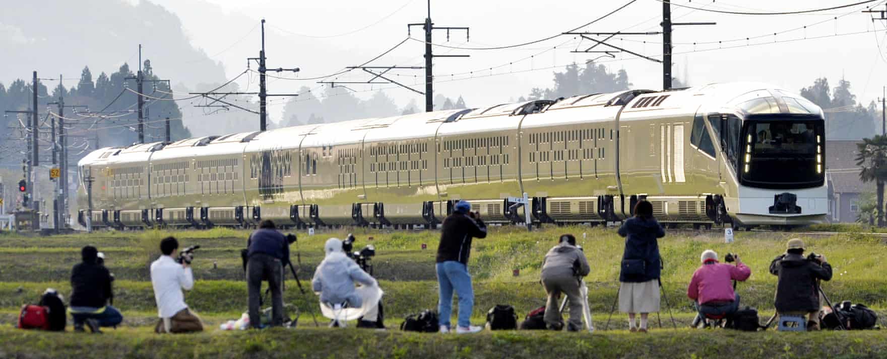 Trainspotters watch the 10-car vehicle cross a field in Nikko, north-east of Tokyo