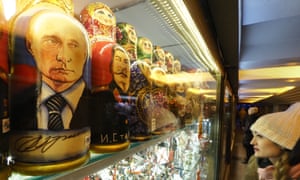 A woman walks past traditional Russian wooden dolls depicting Russian President Vladimir Putin and Joseph Stalin in St Petersburg.