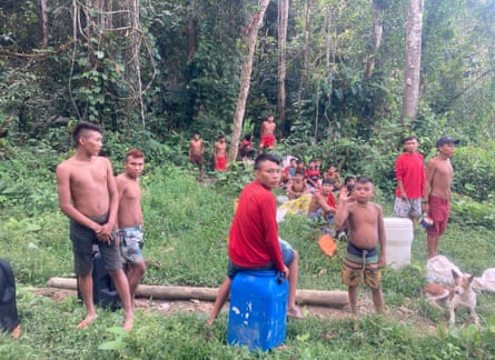Aldeões Yanomami observam tropas ambientais pousar em uma mina ilegal perto de sua comunidade durante uma grande operação para expulsar gangues de garimpeiros