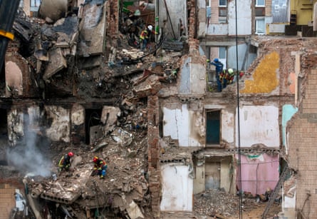 Rescuers sift through a destroyed block of flats