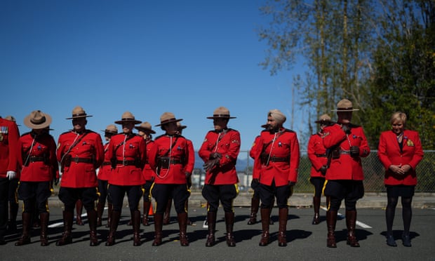 RCMP officers wait for a change of command ceremony and parade to begin in Langley, British Columbia, on Tuesday.
