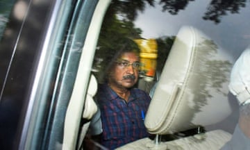 Arvind Kejriwal in the back of a car being driven away from court.