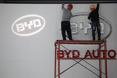 Workers on a scaffold build the BYD stand at an exhibition in China.