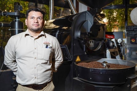 Carlos Guerra stands next to a coffee-bean roaster at Café San Rafael