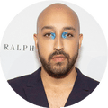 Man with bald head, goatee, and blue eyeshadow in the corners of his eyes