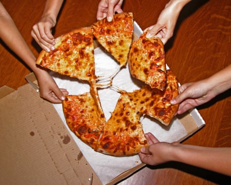 People grabbing slices of pizza, overhead viewGettyImages-200386947-001