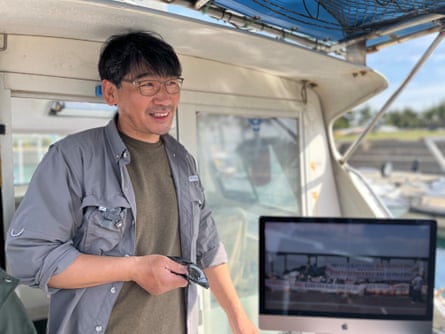 A smiling middle-aged Korean man standing on a boat