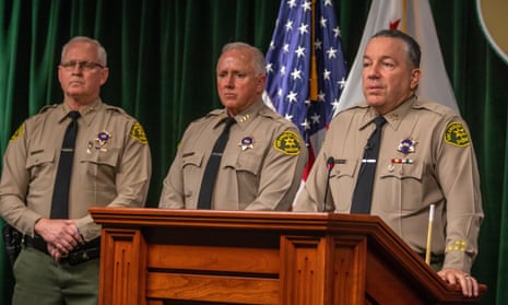 three men wearing law enforcement uniforms behind podium