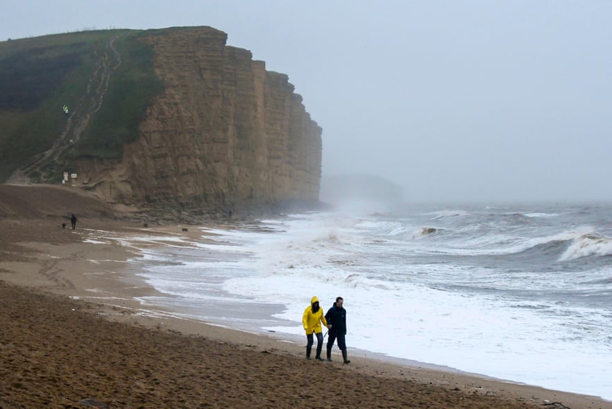 An atmospheric and almost deserted West Bay beach, Dorset, as waves crash ashore.