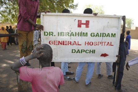 People gather outside the hospital where the freed girls are being treated, in Dapchi.
