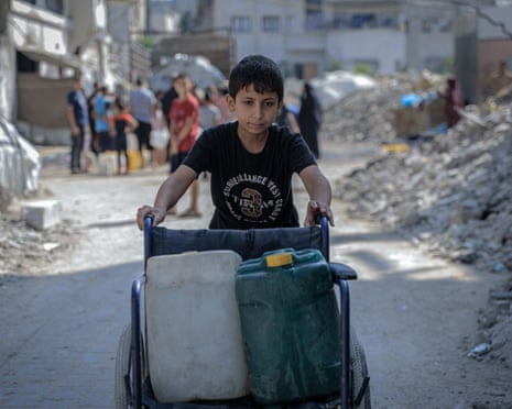 Palestinians living in Gaza City queue in front of water tankers every day to get clean water to their tents, on July 11, 2025 in Gaza.