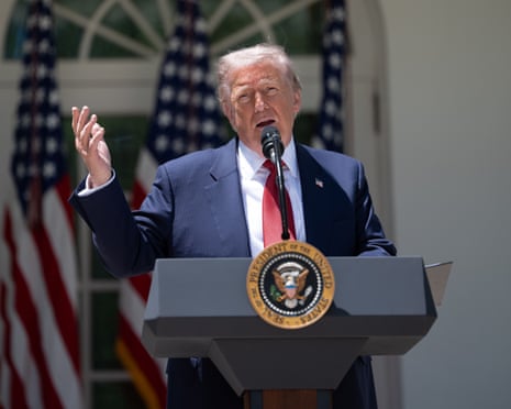 President Donald Trump speaks at a podium with the presidential seal in the Rose Garden.