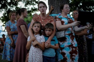 A woman embraces her children as she takes part at a ceremony in memory of the victims of the Robb elementary school shooting
