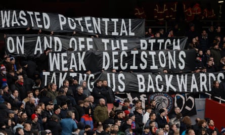 Supporters hold up banners demonstrating their discontentment at Crystal Palace’s owners during defeat at the Emirates