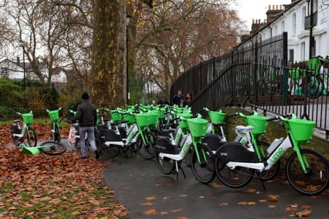 Lime rental bikes parked on a pathway at Eel Brook Common in Fulham, London.