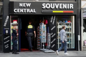 Police officers enforce the closure of a shop in Antwerp