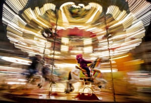 Frankfurt, Germany: a girl rides a horse on a merry-go-round at the Christmas market