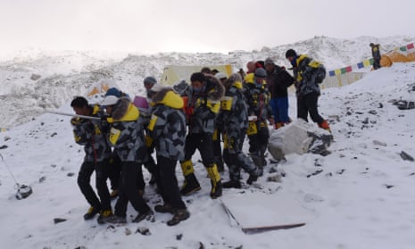Rescuers carry an injured person to a helicopter at Everest base camp.