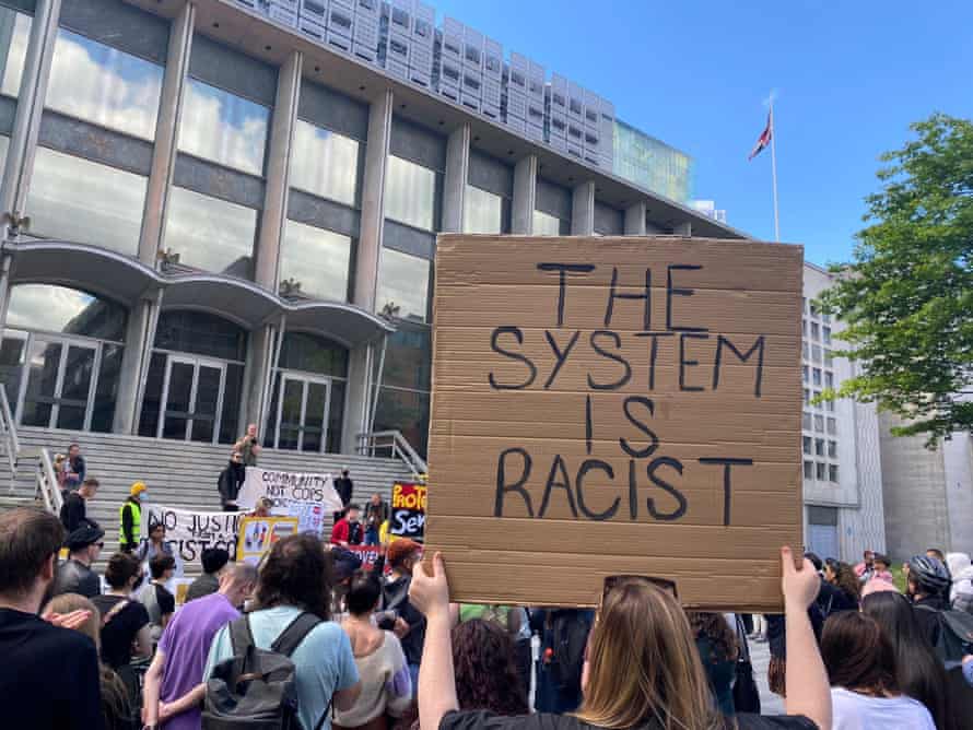 تابلوی اعتراضی با نوشته «سیستم نژادپرستانه است»