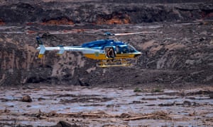 Rescuers in a helicopter search for survivors after the collapse of a mining dam near the town of Brumadinho, Brazil.