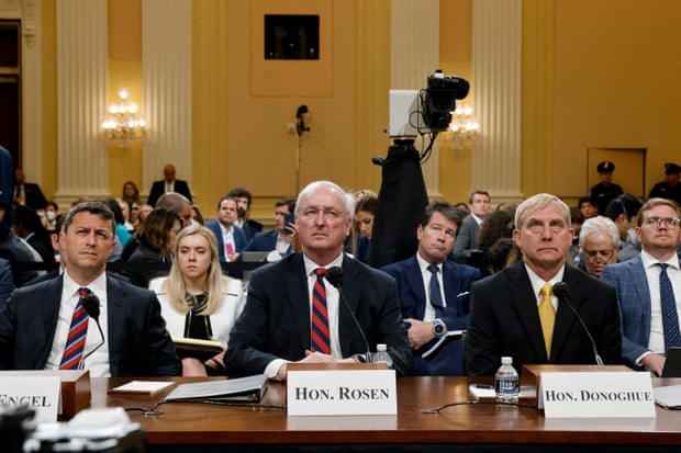 Three men sit at a table during the House hearing.