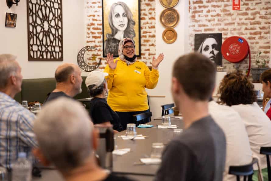 Food tour guide Sahar Elsemary is standing in the restaurant Al Shami speaking to the guests on her tour who are sitting at tables