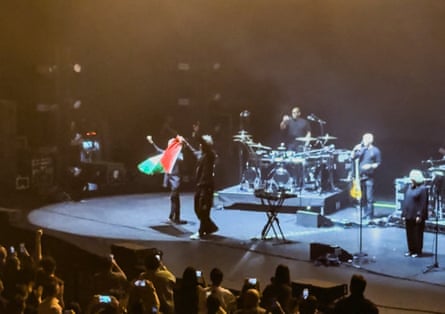 Robert Del Naja and Grant Marshall from Massive Attack stand with a Palestinian flag