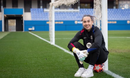 Cata Coll sits on a ball and leans against a post