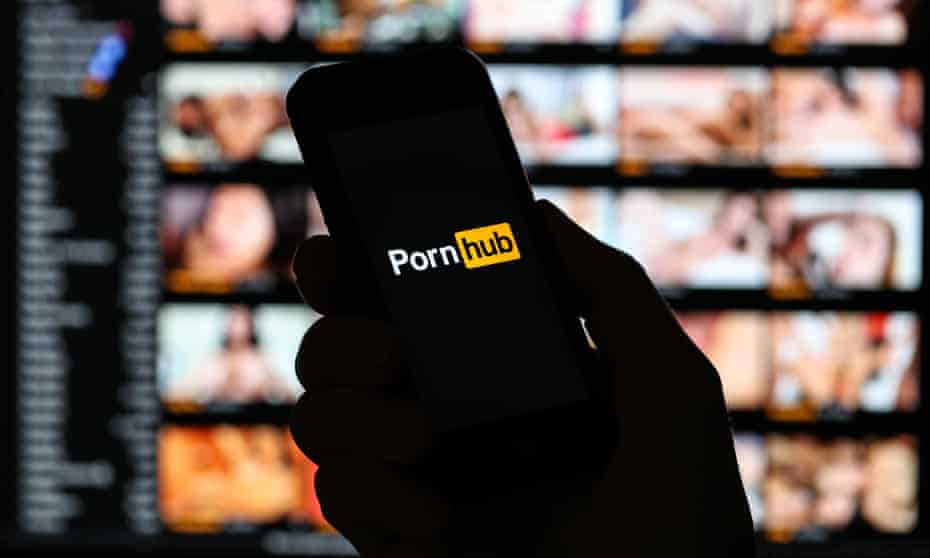 A man looking at the Pornhub.com website logo on his phone