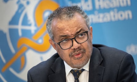 A seated Tedros Adhanom Ghebreyesus in front of a World Health Organization sign 