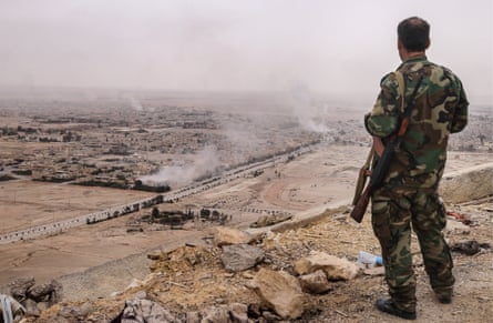 A Syrian government army soldier looks at Palmyra from the top of Fakhr al-Din al-Maani Citadel