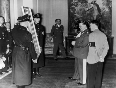 German Field-Marshal Hermann Goering (second from right) admires a painting given to him by Adolf Hitler (right) for his 45th birthday.