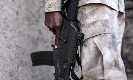 A Haitian national police officer guards the front of the house of Haiti’s prime minister, in Port-au-Prince.