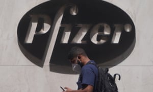 A man walks past a sign outside Pfizer HQ in New York.