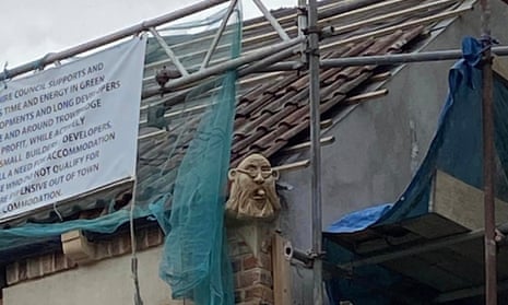 A grotesque carving of  Trowbridge town council leader, Stewart Palmen, on a roof